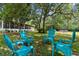 Lush backyard with vibrant blue Adirondack chairs set up for outdoor relaxation and enjoyment at 13444 English Parrot Rd, Brooksville, FL 34614