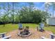 Charming backyard features a fire pit area with Adirondack chairs and mature trees at 13444 English Parrot Rd, Brooksville, FL 34614