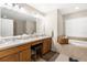 Bathroom featuring double sinks, vanity, and a soaking tub at 13444 English Parrot Rd, Brooksville, FL 34614