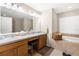 Spacious bathroom with dual sinks, a vanity area, and a separate tub at 13444 English Parrot Rd, Brooksville, FL 34614