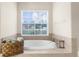 Bathroom featuring soaking tub beneath a window, enhancing relaxation and natural light at 13444 English Parrot Rd, Brooksville, FL 34614