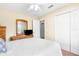 Bright bedroom features a white bedspread, white ceiling fan, closet, and a wooden dresser at 13444 English Parrot Rd, Brooksville, FL 34614