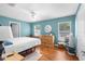 Well-lit bedroom with wood floors, large windows, and a dresser at 13444 English Parrot Rd, Brooksville, FL 34614