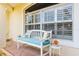 Charming front porch with a white bench, decorative pillows and potted flowers at 13444 English Parrot Rd, Brooksville, FL 34614