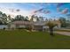 Charming single-story home with a manicured lawn, carport, and a detached two car garage at 13444 English Parrot Rd, Brooksville, FL 34614