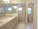 Bathroom featuring double sinks, a walk-in shower, and stylish tiling for a comfortable and practical space at 14112 Whitecap Ave, Hudson, FL 34667