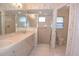 Bathroom with a double sink vanity, tiled floor, and a glass-enclosed shower at 14112 Whitecap Ave, Hudson, FL 34667