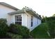 A bright and airy exterior view highlighting the side of the home and green landscaping at 14112 Whitecap Ave, Hudson, FL 34667