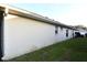 Side view of the house with long, seamless gutters and green grass at 14112 Whitecap Ave, Hudson, FL 34667
