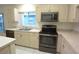 Well-lit kitchen featuring stainless steel appliances and light wood cabinetry at 14112 Whitecap Ave, Hudson, FL 34667