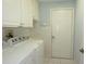 Bright laundry room with washer, dryer, and tiled flooring at 14112 Whitecap Ave, Hudson, FL 34667
