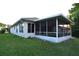 View of the house highlighting the screened in porch and backyard space at 14112 Whitecap Ave, Hudson, FL 34667