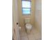 This bathroom has a standard toilet with tiled floors and wallpaper at 14112 Whitecap Ave, Hudson, FL 34667