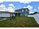 The backyard features a large grassy area, white fence, and a tire swing for outdoor enjoyment at 15160 Durango Cir, Brooksville, FL 34604