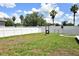 Large backyard features a white fence, grassy area, tire swing and decorative landscaping at 15160 Durango Cir, Brooksville, FL 34604