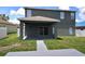Covered patio with sliding glass doors, grey flooring and access to the grassy backyard at 15160 Durango Cir, Brooksville, FL 34604