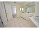 Bright bathroom featuring double sinks, white cabinets, and neutral tile flooring at 15160 Durango Cir, Brooksville, FL 34604