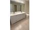Bathroom featuring dual sinks, soaking tub and oversized mirror at 15160 Durango Cir, Brooksville, FL 34604