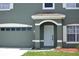 Close-up view of a two-story home's garage, arched entryway, and manicured front yard at 15160 Durango Cir, Brooksville, FL 34604