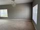 Spacious living room with neutral-colored walls, carpeted floor, large window, and chandelier at 15160 Durango Cir, Brooksville, FL 34604