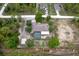 A home with a screened in pool and lush green trees in the backyard is shown from above at 15287 Coot Rd, Weeki Wachee, FL 34614