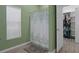 Bathroom with window, shower with decorative curtain, and open door to a closet with built-in shelving at 15287 Coot Rd, Weeki Wachee, FL 34614