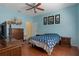 Bright bedroom featuring blue walls, ceiling fan and wood-look floors at 15287 Coot Rd, Weeki Wachee, FL 34614