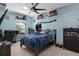Comfortable bedroom featuring a desk with a monitor, a bed, and decor on shelves along a blue wall at 15287 Coot Rd, Weeki Wachee, FL 34614