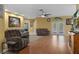 Spacious living room with wood floors, neutral walls, a ceiling fan and comfortable seating arrangement at 15287 Coot Rd, Weeki Wachee, FL 34614