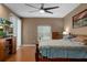 Spacious primary bedroom with a ceiling fan, natural light, and wood floors at 15287 Coot Rd, Weeki Wachee, FL 34614