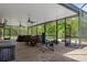 This screened-in patio has pavers, ceiling fans, and forest views, perfect for outdoor living at 15287 Coot Rd, Weeki Wachee, FL 34614
