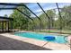 A pool with brick pavers is surrounded by a screen enclosure and a thicket of trees at 15287 Coot Rd, Weeki Wachee, FL 34614