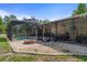 Screened-in pool with brick fire pit and covered patio, perfect for outdoor entertaining and enjoying the backyard view at 15287 Coot Rd, Weeki Wachee, FL 34614