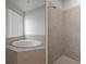 Luxurious bathroom featuring a soaking tub with jets and a separate tiled walk-in shower at 15569 Burbank Dr, Brooksville, FL 34604