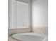 Bathtub with tile surround and window with privacy blinds at 15569 Burbank Dr, Brooksville, FL 34604