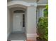 Close-up of a home's entrance showing the front door with sidelights and an arched transom window at 15569 Burbank Dr, Brooksville, FL 34604