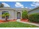 Close-up of a charming home highlighting the front door, meticulously manicured landscaping, and vibrant mulch at 15569 Burbank Dr, Brooksville, FL 34604