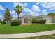 Inviting single-story home showcasing a lush front lawn, mature landscaping, and a two-car garage under a cloudy sky at 15569 Burbank Dr, Brooksville, FL 34604
