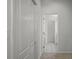 Bright hallway with neutral tones and carpeted floors that lead to a tiled bathroom at 15569 Burbank Dr, Brooksville, FL 34604