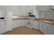 Clean kitchen featuring white cabinets, appliances, and tile flooring at 15569 Burbank Dr, Brooksville, FL 34604