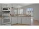 Kitchen with white appliances and cabinets plus a breakfast bar at 15569 Burbank Dr, Brooksville, FL 34604
