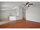 Spacious living room with hardwood floors, a ceiling fan, and seamless transition to an open-concept kitchen at 15569 Burbank Dr, Brooksville, FL 34604