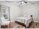 Bright bedroom features wood floors, a ceiling fan and large window at 1601 E 98Th Ave, Tampa, FL 33612