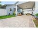 Paver driveway leading to a covered carport and patio area, offering ample parking and outdoor living space at 1601 E 98Th Ave, Tampa, FL 33612