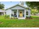 Charming single-story home featuring a yellow front door and beautifully landscaped front yard at 1601 E 98Th Ave, Tampa, FL 33612