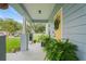 Charming covered front porch with a yellow door, lovely green plants and seating at 1601 E 98Th Ave, Tampa, FL 33612