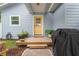 Charming front porch with a yellow door, potted plants, and a wooden deck, creating a welcoming entrance at 1601 E 98Th Ave, Tampa, FL 33612