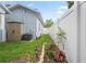 Landscaped side yard with well-maintained grass, flowerbeds, and a white fence, enhancing the property's appeal at 1601 E 98Th Ave, Tampa, FL 33612