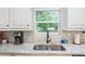 Kitchen sink with stainless steel faucet, granite countertops, and window view at 1601 E 98Th Ave, Tampa, FL 33612