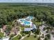 Aerial view showcasing the community pool, surrounded by lush landscaping, seating areas, and recreational facilities at 17316 Cruiser Bnd, Land O Lakes, FL 34638